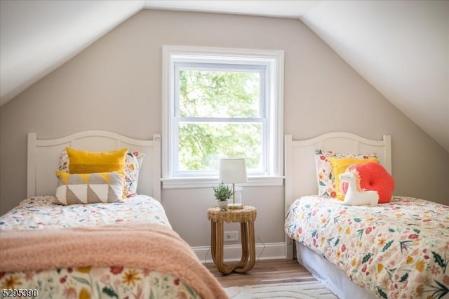 bedroom featuring lofted ceiling and light wood-type flooring