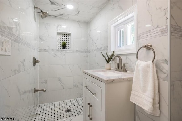 bathroom featuring a tile shower and vanity