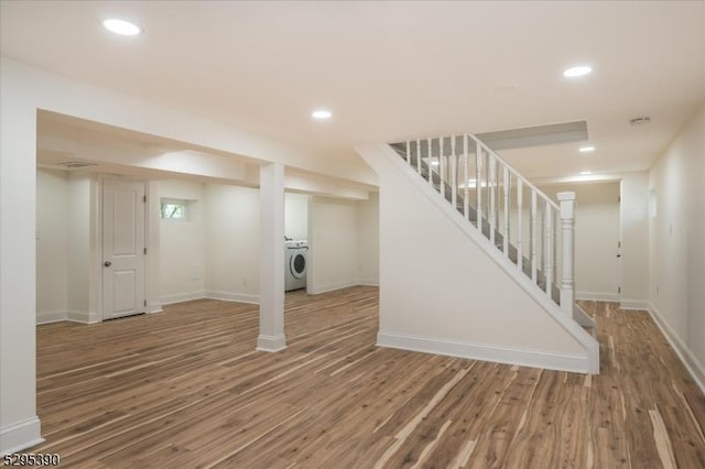 basement with washer / clothes dryer and wood-type flooring