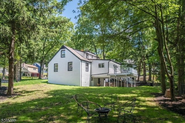 rear view of house with a deck and a lawn