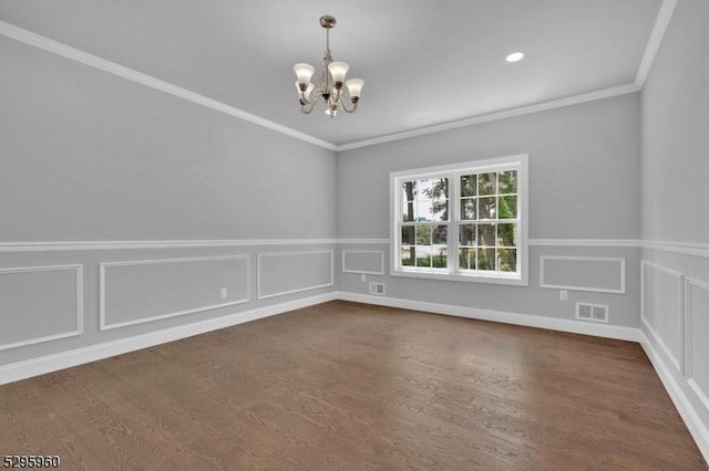 unfurnished room with dark wood-type flooring, an inviting chandelier, and crown molding