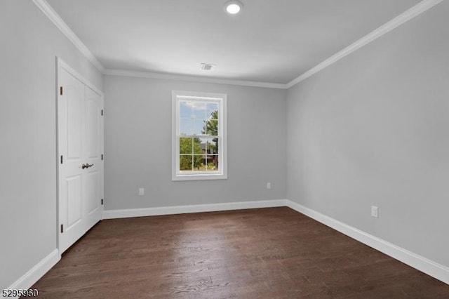 spare room featuring dark hardwood / wood-style floors and crown molding