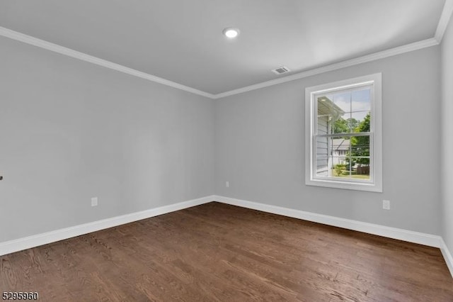 empty room featuring dark hardwood / wood-style flooring and ornamental molding