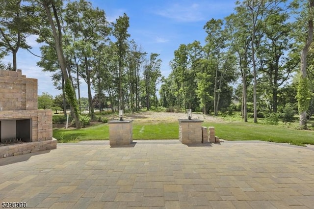 view of patio featuring an outdoor stone fireplace