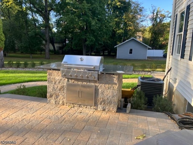 view of patio / terrace with a grill, exterior kitchen, and central AC unit