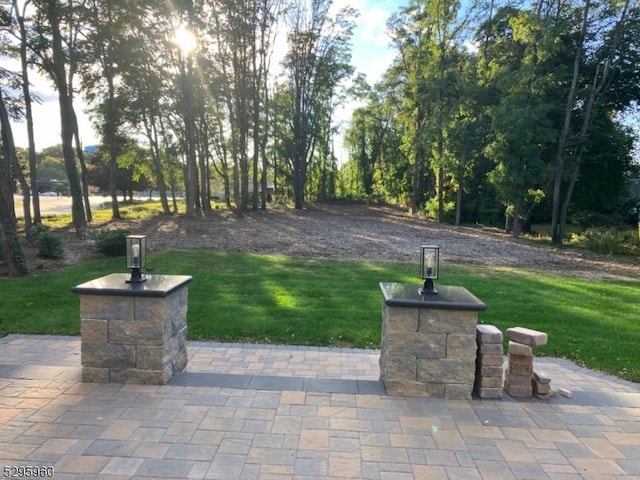 view of home's community with a patio area and a lawn