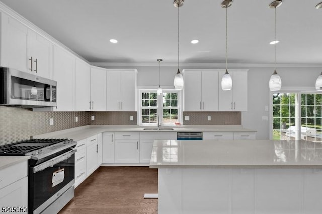 kitchen featuring white cabinetry, pendant lighting, stainless steel appliances, and sink