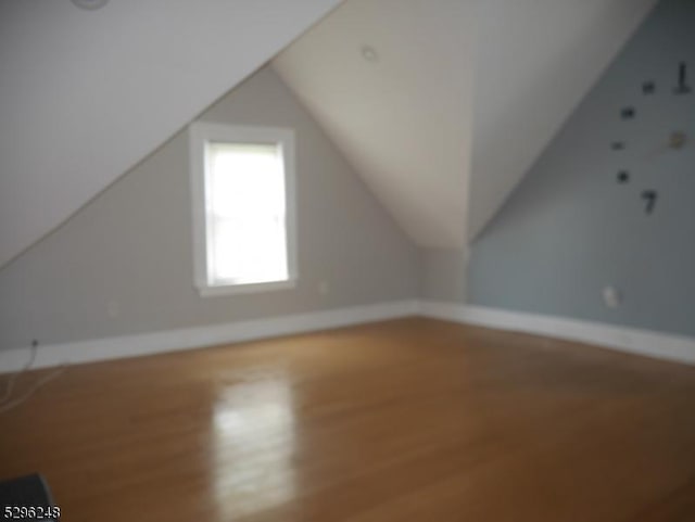 bonus room featuring wood-type flooring and vaulted ceiling