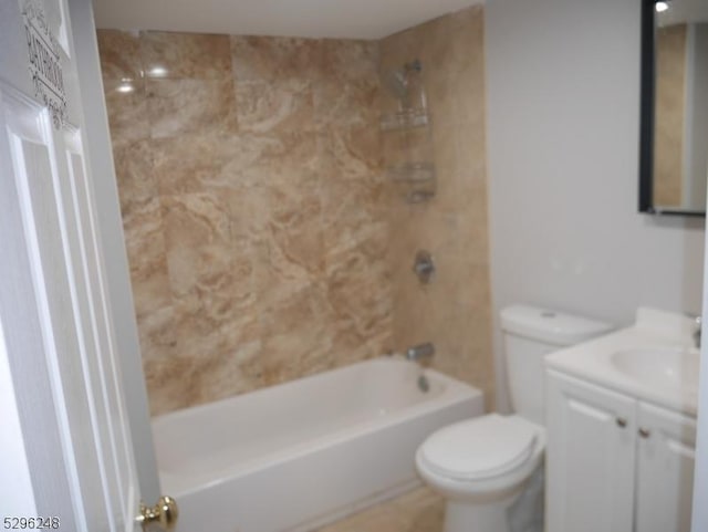 full bathroom featuring tiled shower / bath combo, toilet, and vanity