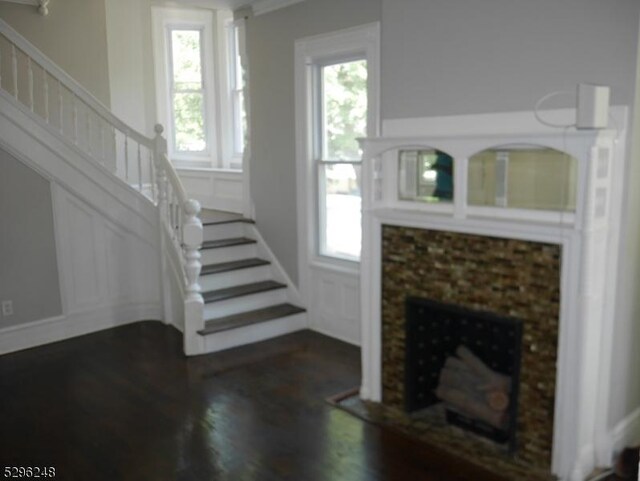 unfurnished living room featuring a healthy amount of sunlight and dark hardwood / wood-style flooring