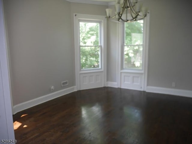 unfurnished room featuring hardwood / wood-style flooring, a chandelier, and ornamental molding