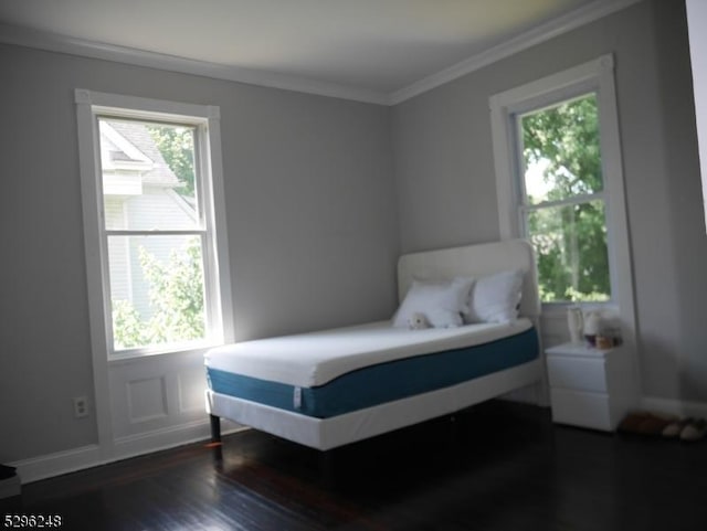 bedroom with multiple windows, dark hardwood / wood-style floors, and ornamental molding