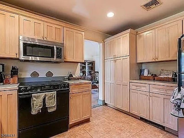 kitchen with light brown cabinets and black electric range oven