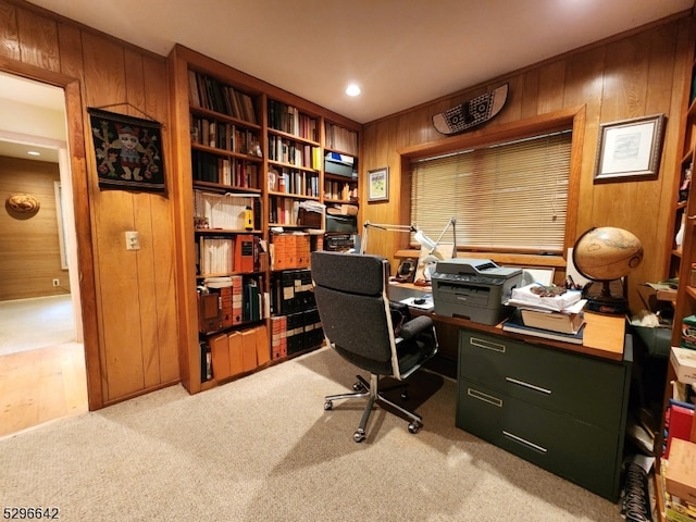 home office with wood walls and light colored carpet