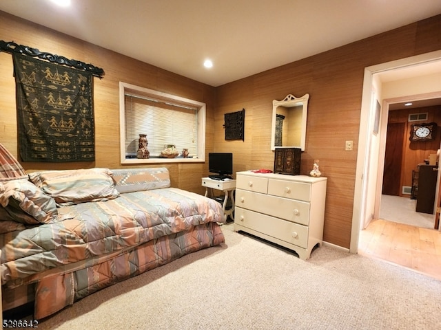 carpeted bedroom with wooden walls