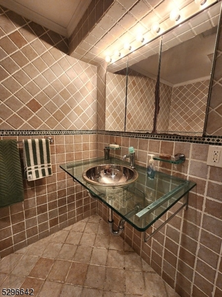 bathroom with tile walls, tile floors, sink, and tasteful backsplash