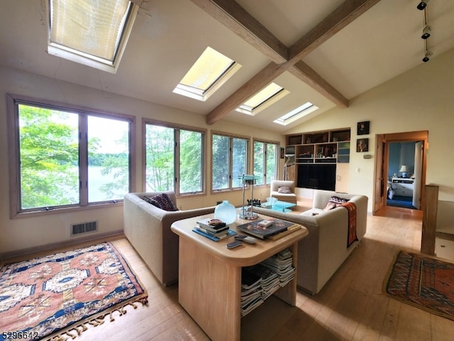 living room featuring lofted ceiling with skylight and light hardwood / wood-style flooring