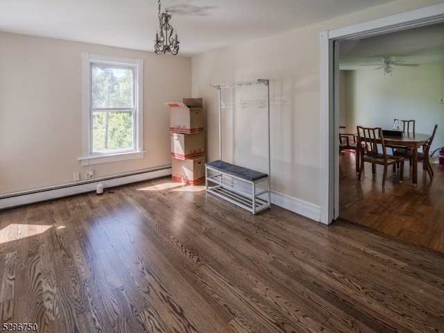 interior space featuring a baseboard heating unit, ceiling fan with notable chandelier, and dark hardwood / wood-style flooring