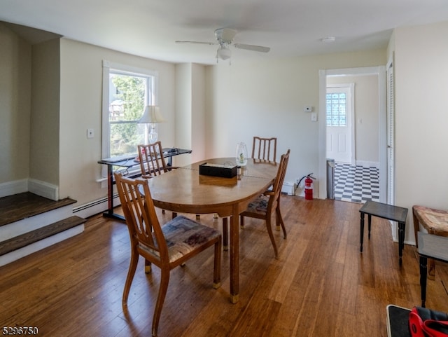 dining area featuring ceiling fan, baseboard heating, and hardwood / wood-style floors