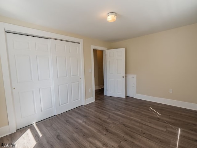 unfurnished bedroom featuring a closet and dark hardwood / wood-style flooring