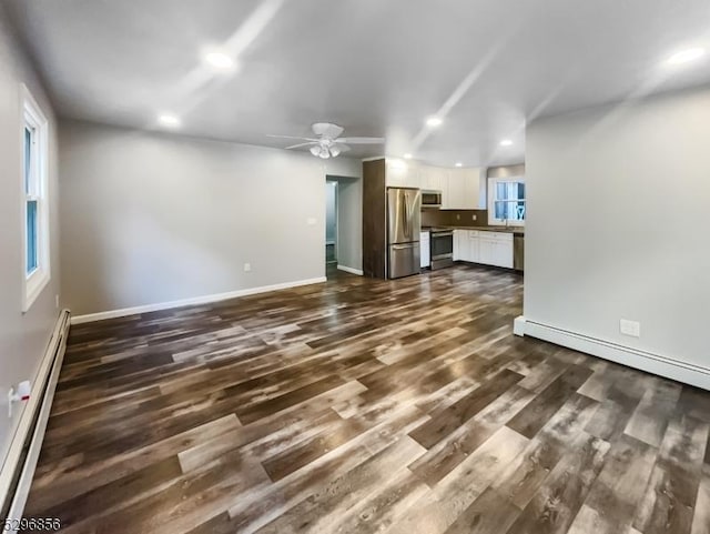 unfurnished living room featuring ceiling fan, a baseboard radiator, and dark wood-type flooring