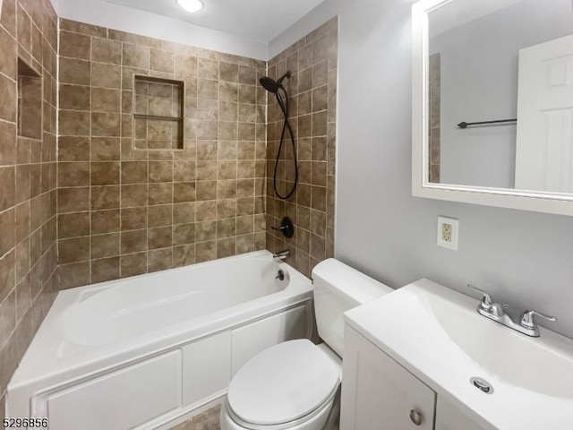 full bathroom featuring tiled shower / bath combo, toilet, and vanity