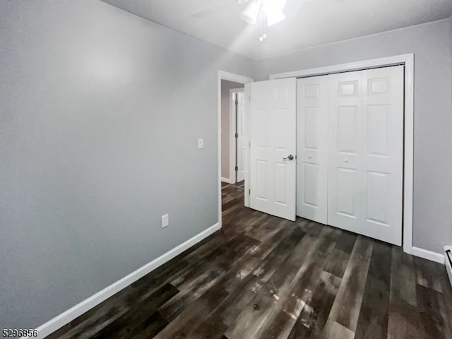 unfurnished bedroom featuring ceiling fan, dark wood-type flooring, and a closet