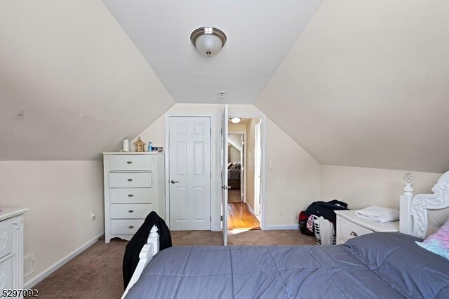 carpeted bedroom with baseboards and lofted ceiling