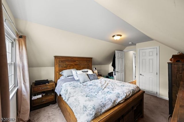 carpeted bedroom featuring vaulted ceiling and baseboards