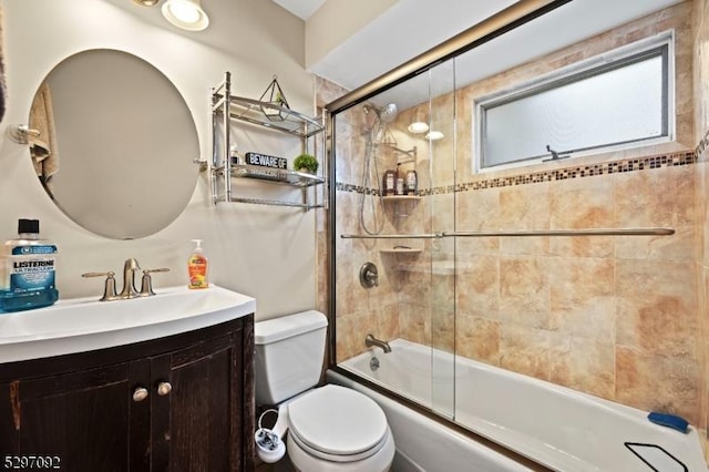 full bath featuring toilet, enclosed tub / shower combo, and vanity