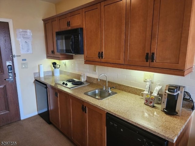 kitchen featuring sink, tasteful backsplash, light stone counters, and black appliances