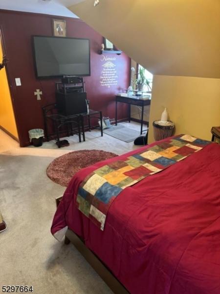 bedroom featuring vaulted ceiling and light colored carpet