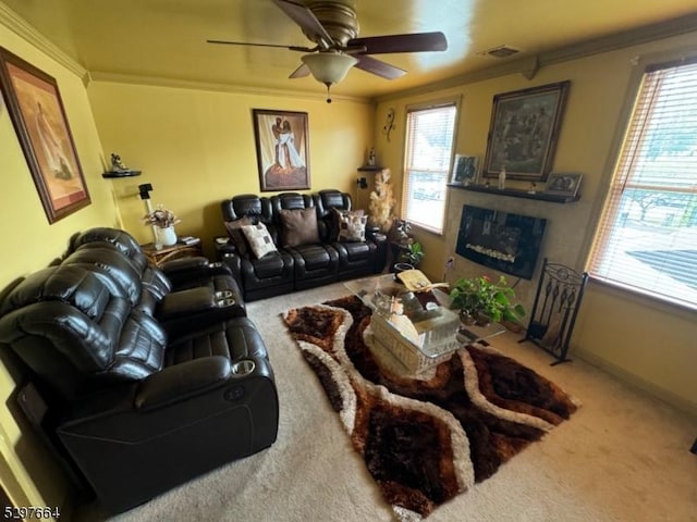 carpeted living room with ornamental molding and ceiling fan