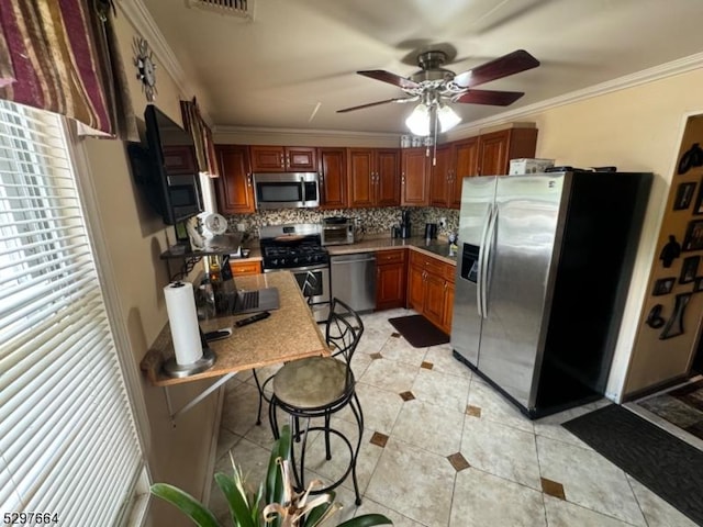 kitchen featuring crown molding, ceiling fan, appliances with stainless steel finishes, tasteful backsplash, and light tile patterned flooring