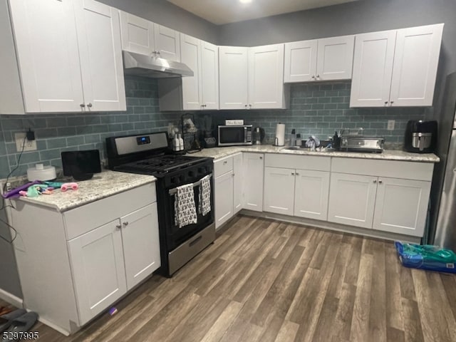 kitchen with dark hardwood / wood-style floors, stainless steel appliances, backsplash, and white cabinetry