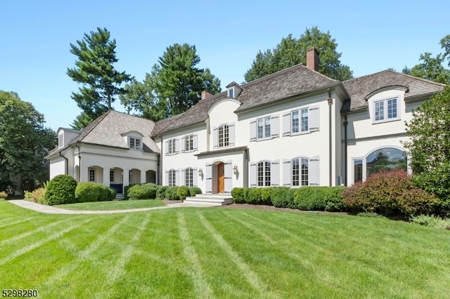 french provincial home with a front yard