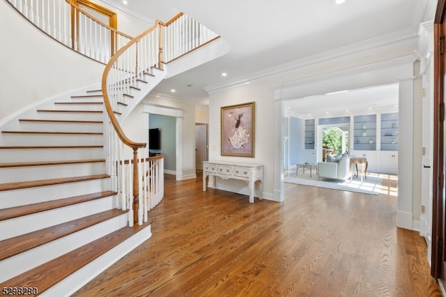 interior space featuring crown molding, wood-type flooring, and built in features