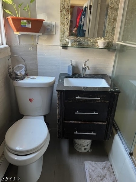 full bathroom with vanity, toilet, and combined bath / shower with glass door