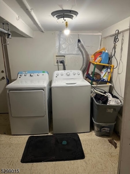 clothes washing area featuring tile patterned flooring and washer and clothes dryer