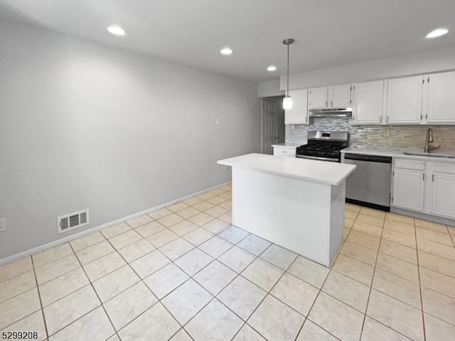 kitchen featuring appliances with stainless steel finishes, tasteful backsplash, pendant lighting, light tile patterned floors, and white cabinetry