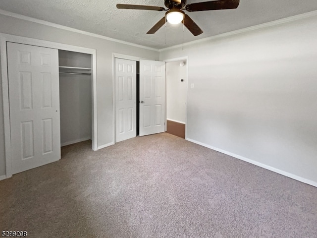 unfurnished bedroom featuring two closets, carpet floors, a textured ceiling, and ceiling fan