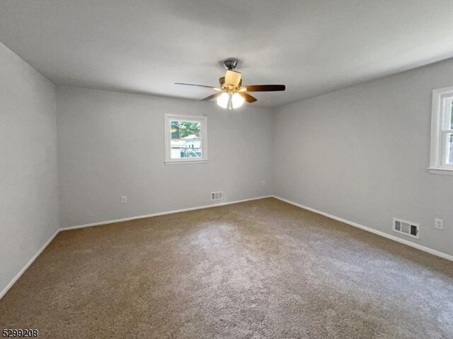 carpeted spare room featuring ceiling fan