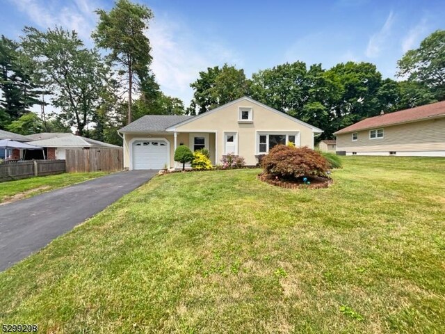 single story home featuring a garage and a front lawn