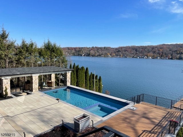 view of pool featuring a water view and a patio