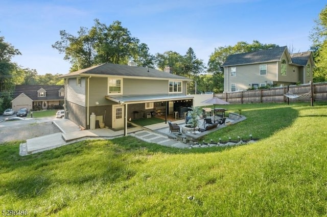 back of property with a yard and a patio