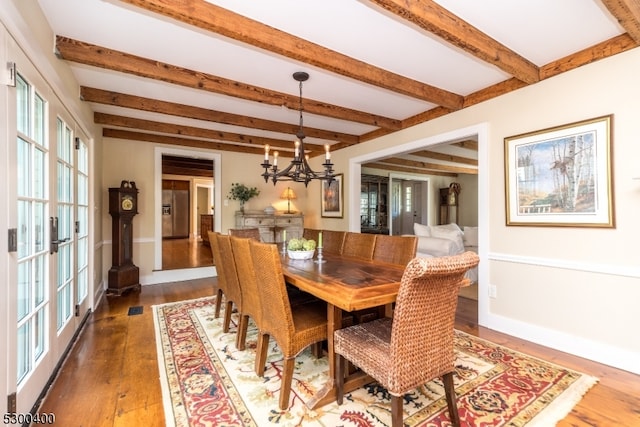 dining area featuring french doors, wood-type flooring, a notable chandelier, and beam ceiling