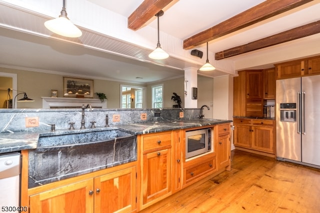 kitchen with beam ceiling, light hardwood / wood-style flooring, hanging light fixtures, appliances with stainless steel finishes, and sink