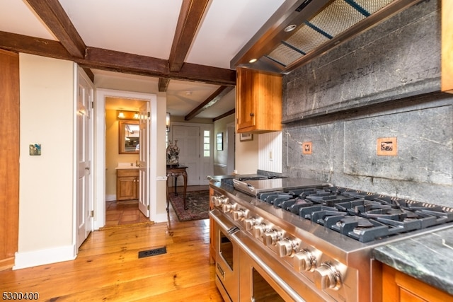 kitchen with beamed ceiling, tasteful backsplash, light hardwood / wood-style floors, high end range, and custom range hood