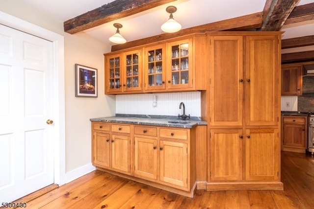 kitchen featuring light hardwood / wood-style floors, sink, beam ceiling, and tasteful backsplash