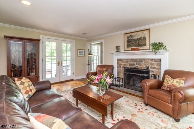 living room featuring crown molding, a stone fireplace, french doors, and hardwood / wood-style floors